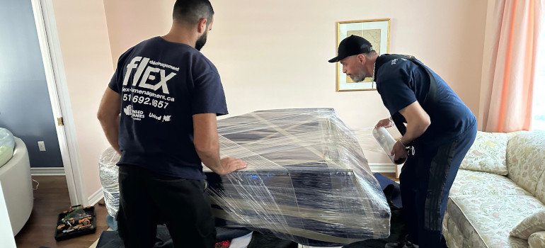 Our professional movers from Flex Moving wrapping and preparing a piano for safe transport in Montreal