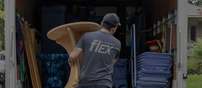 Déménageur Flex chargeant une table ronde dans un camion garni de couvertures de protection
